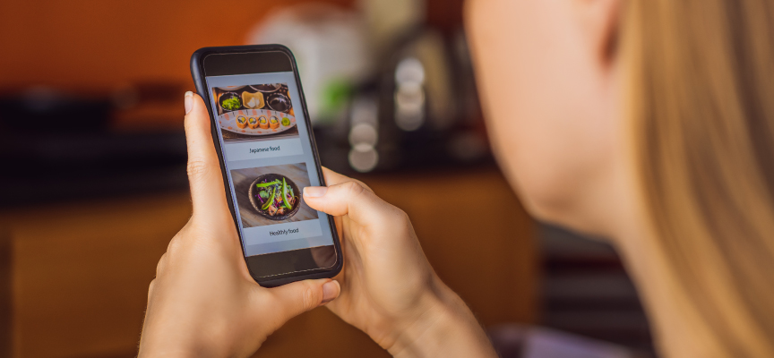 Customer browsing the Smiles app on a smartphone to choose online food ordering from top-rated restaurants in the UAE.
