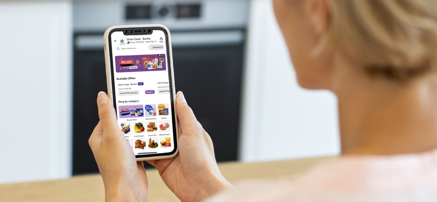 Customer browsing the Smiles Groceries app on a smartphone to select online supermarket essentials and daily grocery items.