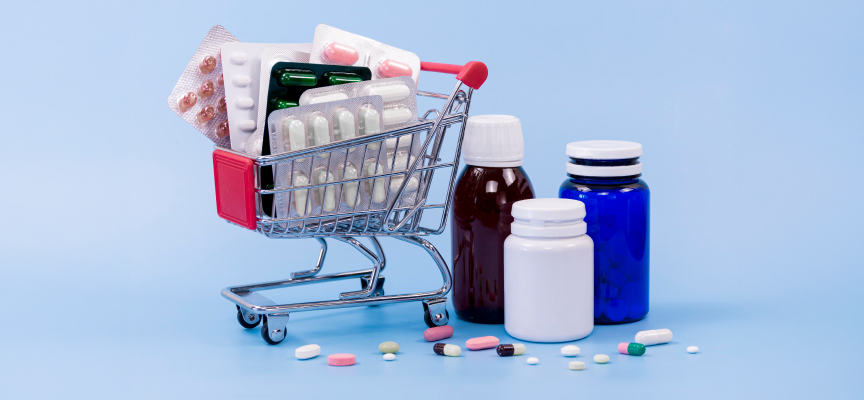 Prescription medicine bottles, pill tablets, and healthcare supplies in a shopping cart for online pharmacy ordering.