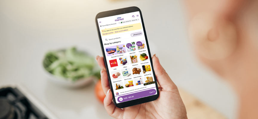 A user browsing the online grocery marketplace app to select daily essentials and grocery categories in Dubai.