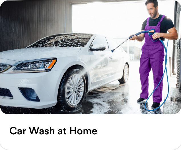 Mobile car wash professional using a high-pressure water sprayer for eco-friendly door-to-door car detailing services.
