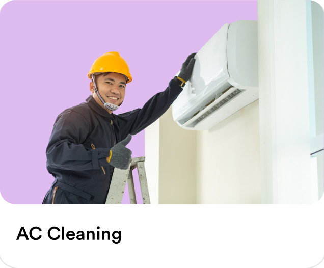 Certified technician wearing a safety hard hat repairing and cleaning an indoor air conditioning split unit for residential AC maintenance.