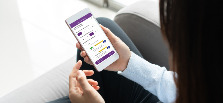 Customer browsing the house maintenance app on a smartphone to select professional home cleaning services.