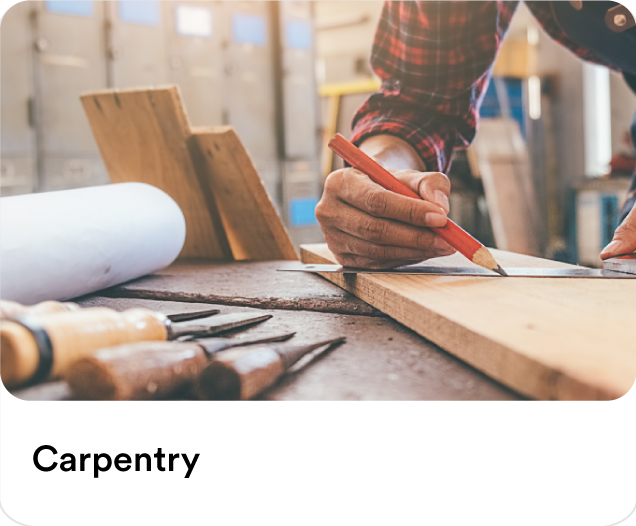 Close-up of a carpenter marking a wooden plank with a pencil to illustrate custom wood repairs and professional carpentry services in the UAE.
