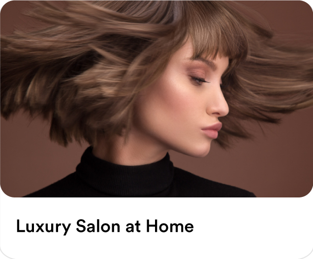 Woman with a stylish brown bob haircut and bangs showing off hair blowout results for luxury salon at home beauty services.